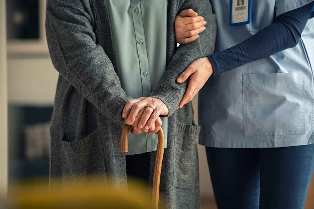 Image of health care worker helping an elderly patient. 