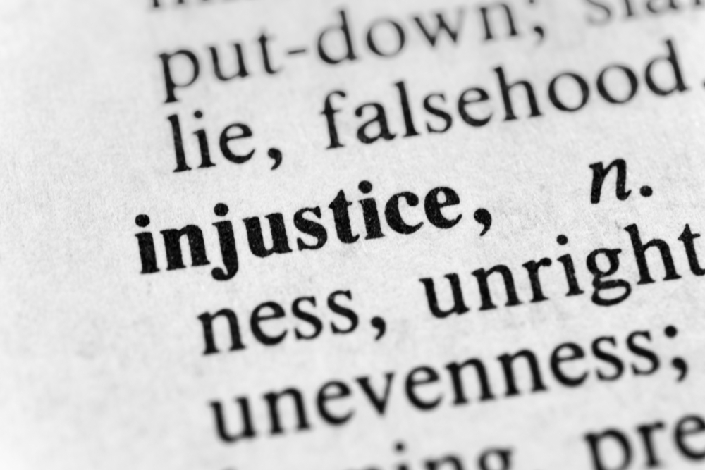 Decorative image of a dictionary page showing the word injustice.
